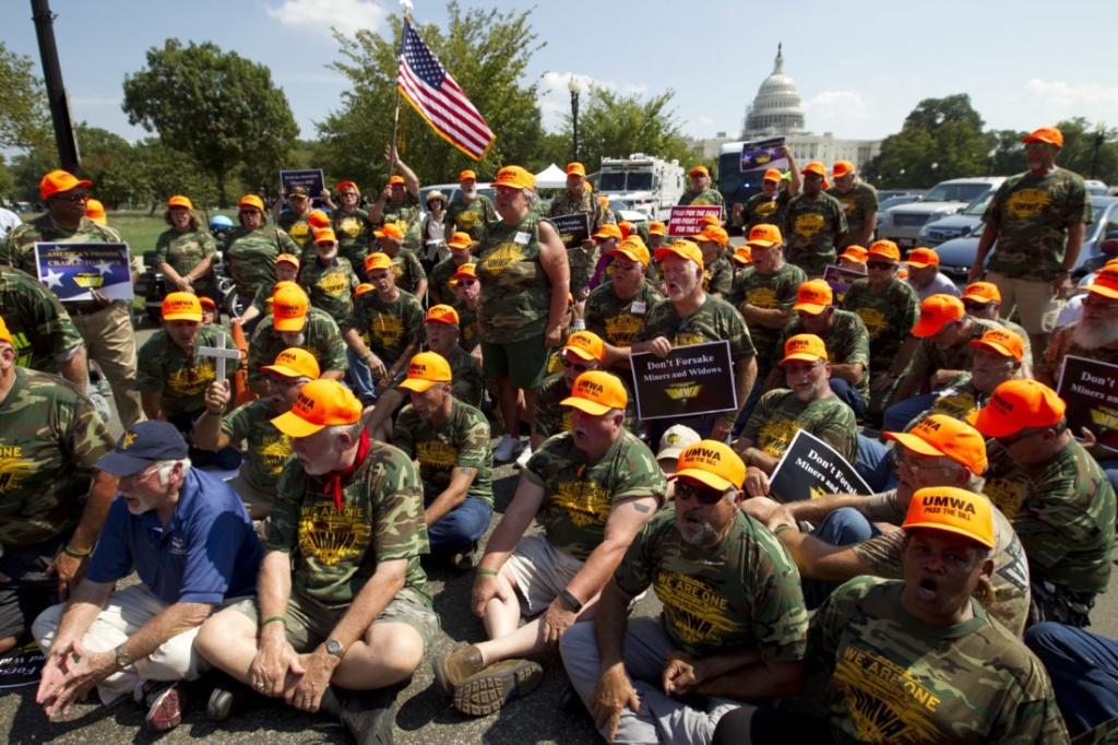 United Mine Workers of America sit on Pennsylvania Avenue in Washington Thursday Sept. 8 2016 during the rally on Capitol Hill in Washington. Thousands of unionized mine workers and supporters rallied to push for a bill that would protect health-care