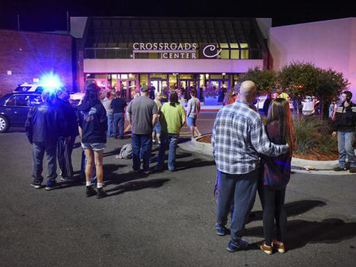 People stand near the entrance on the north side of Crossroads Center mall between Macy's and Target as officials investigate a reported multiple stabbing incident Saturday Sept. 17 2016 in St. Cloud Minn. Police said multiple people were injure