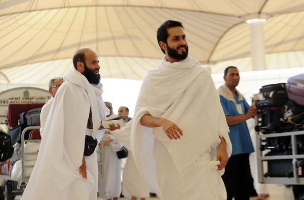 Muslim pilgrims walk outside the King Abdul Aziz airport upon their arrival to the Red Sea port city of Jeddah on Sunday