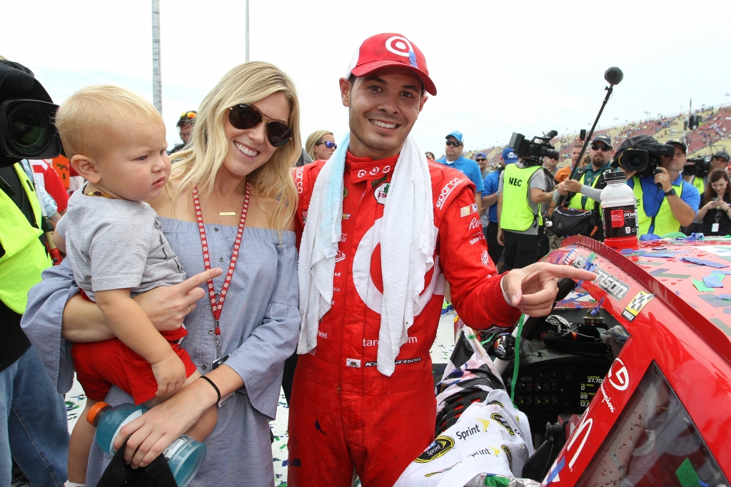 BROOKLYN MI- AUGUST 28 Kyle Larson driver of the #42 Target Chevrolet girlfriend Katelyn Sweet and son Owen Larson affixe the winners decal to his car in Victory Lane after winning the NASCAR Sprint Cup Series Pure Michigan 400 at Michigan Internat