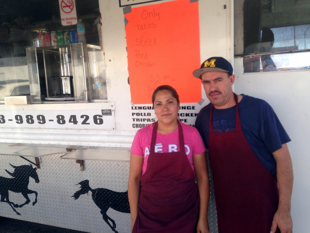 Nancy Paz and Jose Badajoz stand in front of their taco truck which they positioned near the church Donald Trump visited Saturday morning