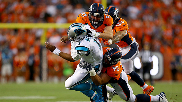 Cam Newton of the Carolina Panthers is hit by defensive ends Derek Wolfe and Jared Crick of the Denver Broncos