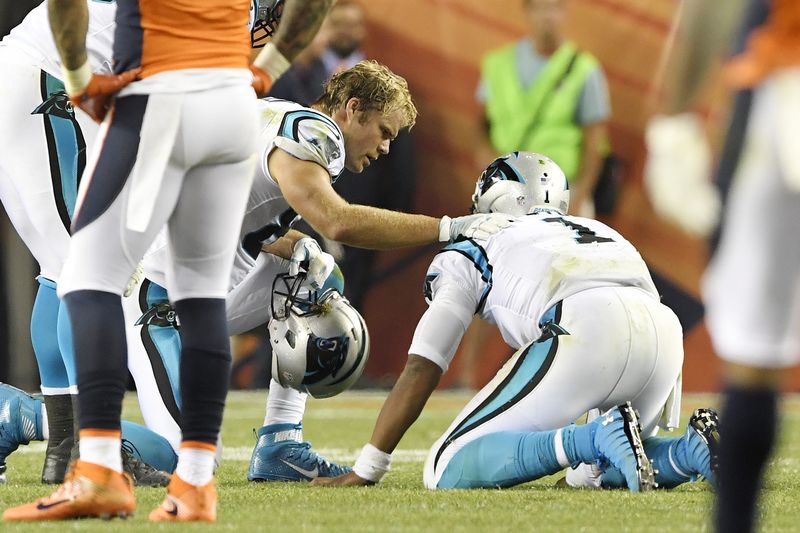 Greg Olsen of the Carolina Panthers checks the health of his quarterback Cam Newton after he got leveled in the Panthers&#x27 season opener on September 8