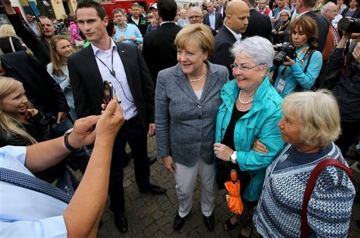 German Chancellor Angela Merkel, center poses with supporters during an election campaign event in Bad Doberan eastern Germany Saturday Sept. 3 3016. Chancellor Angela Merkel's decision a year ago to open the borders to a surge of migrants is casti