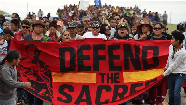 Native Americans marching to a sacred burial ground disturbed by bulldozers building the Dakota Access Pipeline