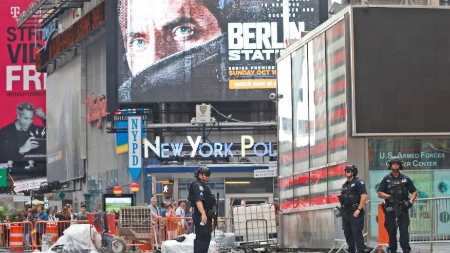 Heavily armed police officers stand guard in the Armed Forces recruitment center island in Time Square Sunday Sept. 18 2016 in New York. Gov. Cuomo said 1,000 additional law enforcement officers were being deployed after the Saturday night blast in Ch