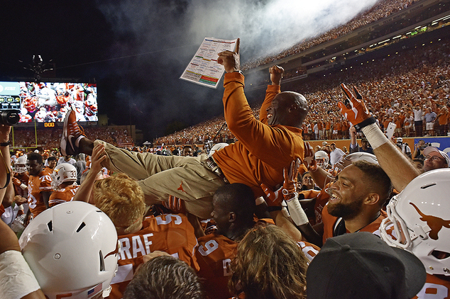 Texas head coach Charlie Strong is carried by players after defeating Notre Dame in double overtime of an NCAA coll