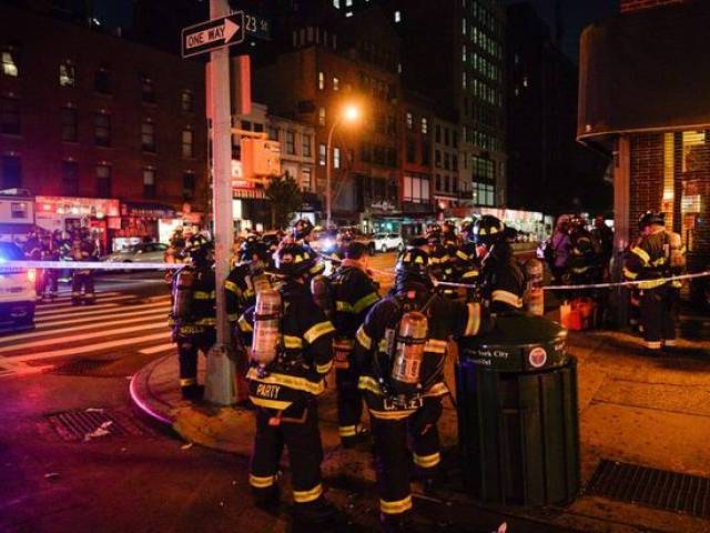 New York City firefighters stand near the site of the blast