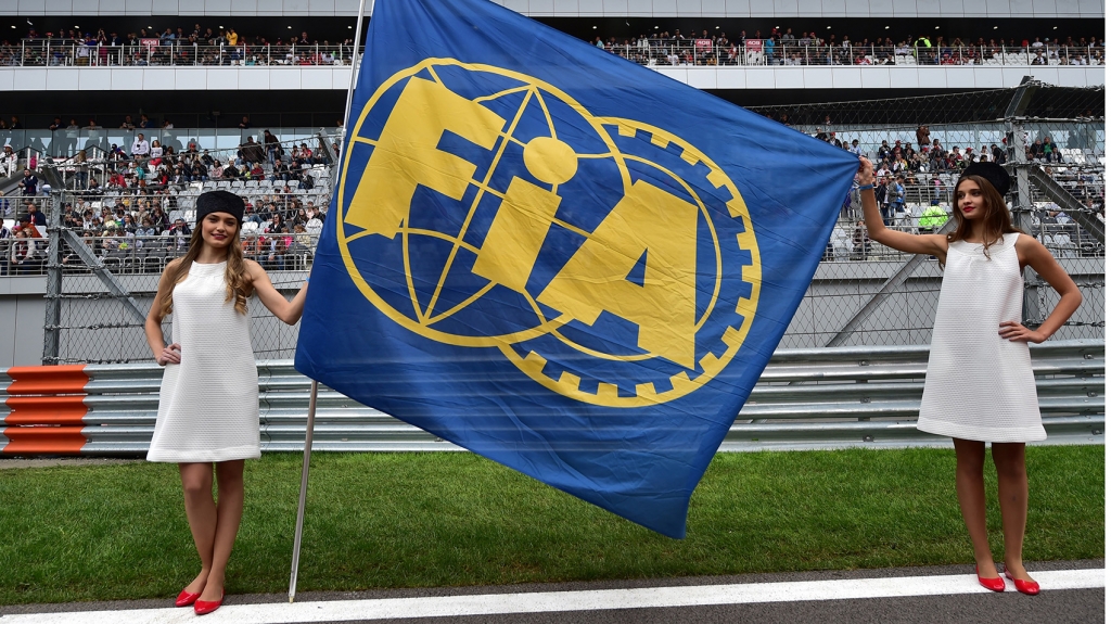 Grid girls pose with a FIA flag before the start of the Russian Formula One Grand Prix at the Sochi Autodrom circuit in Sochi on Oct. 11 2015