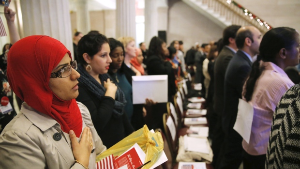 Newly naturalized citizens recite the United States Pledge of Allegiance during a naturalization ceremony in a 2015 file