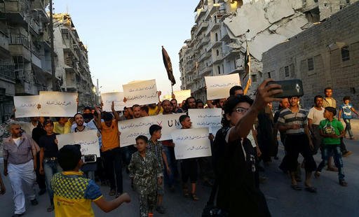 Activists in Syria’s besieged Aleppo protest against the United Nations for what they say is its failure to lift the siege off their rebel-held area Tuesday Sept. 13 2016. Dozens of protesters marched in al Shaar neighborhood heading toward the Cast