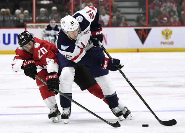 Team Canada's Jonathan Tavares left tries to knock the puck away from Team United States Derek Stepan during the first period of an exhibition World Cup