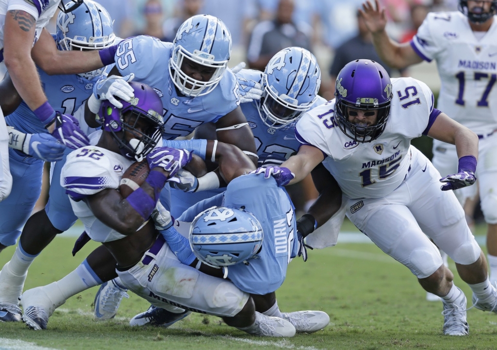 North Carolina’s Jason Strowbridge, Cayson Collins and Myles Dorn try to stop James Madison’s Khalid Abdullah from scoring as James Madison’s Daniel Schiele blocks in the first half of an NCAA college football game in Chapel Hill N.C