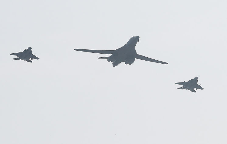 A U.S. B-1B Lancer bomber is escorted by two South Korean F-15K fighters during a flyover Tuesday at Osan Air Base south of Seoul. The flight was intended as a show of force