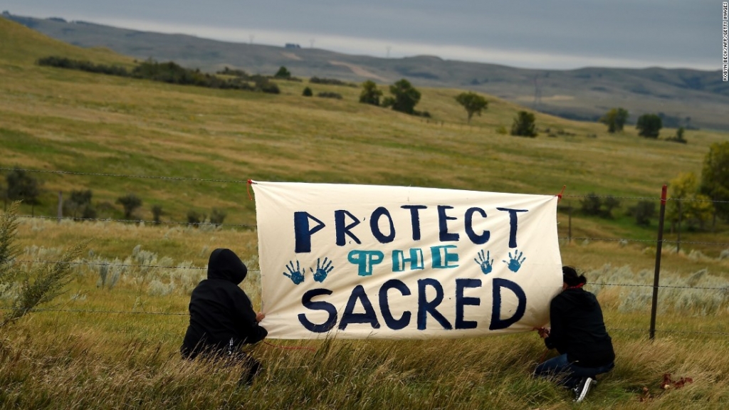 People hang a sign near a burial ground sacred site that they say was disturbed by bulldozers building the Dakota Access Pipeline. Proponents say the project could be an economic boon for the region and potentially change the landscape of the US crude oil