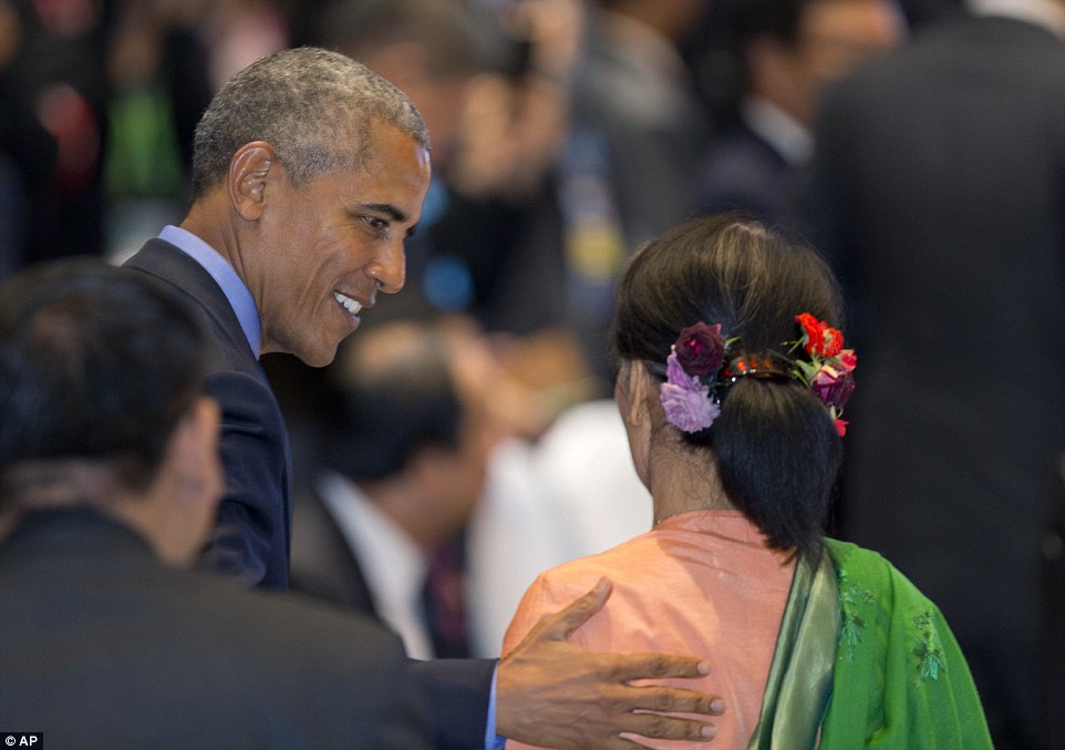 Obama smilies as he greets Myanmar's Foreign Minister Aung San Suu Kyi during the summit in Laos