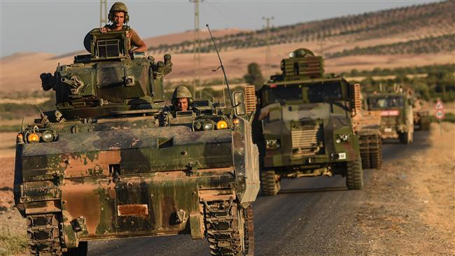 Turkish soldiers stand in a Turkish army tank driving back to Turkey from the Syrian Turkish border town of Jarabulus