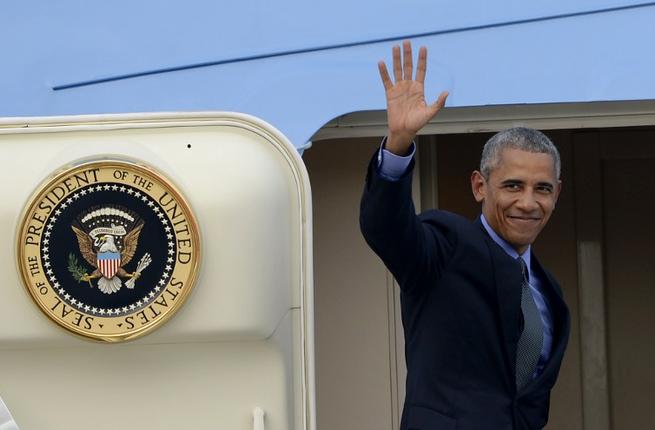 US President Barack Obama waves as he boards Air Force One following the closing ceremony of the Association of Southeast Asian Nations, at the Wattay International Airport in Vientiane