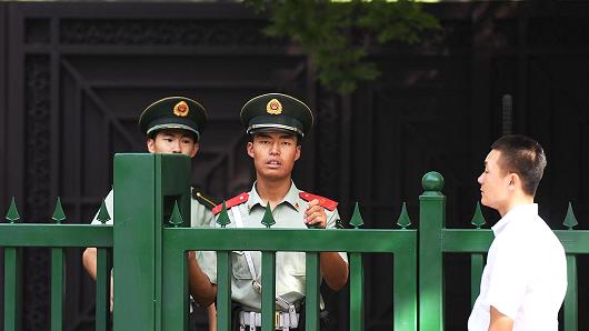 Chinese paramilitary policemen stand outside the entrance to the North Korean embassy in Beijing