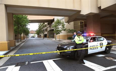 A police officer stands guard near the scene of a shooting on Saturday Sept. 3 2016 in Atlantic City N.J. Authorities say a New Jersey police officer remains in critical condition after he was shot during an exchange of gunfire outside an Atlantic City