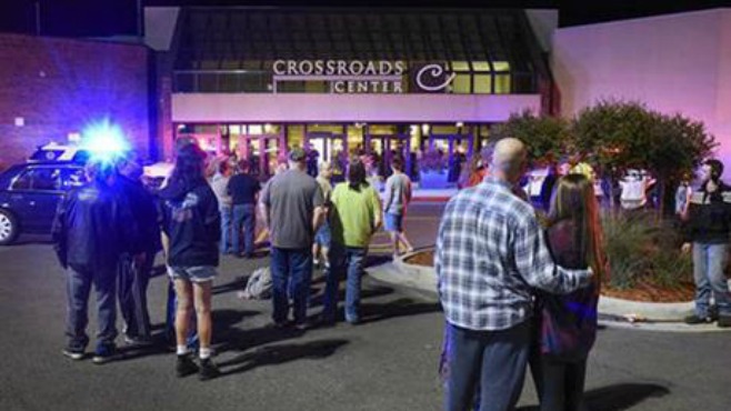 Caption People stand near the entrance on the north side of Crossroads Center mall between Macy's and Target as officials investigate a reported multiple stabbing incident Saturday Sept. 17 2016 in St. Cloud Minn. Police said multiple people