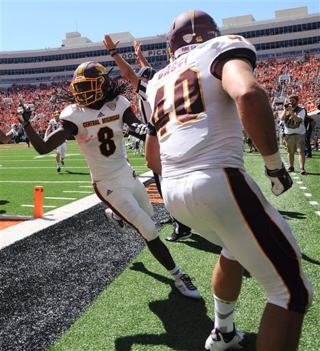 A referee signals a touchdown as Central Michigan wide receiver Corey Willis celebrates with his teammate running back Joe Bacci after scoring the winning touchdown in the final seconds of an NCAA college football game between against Oklahoma St