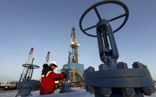 A worker checks an oil pipe at the Lukoil-owned Imilorskoye oil field outside the West Siberian city of Kogalym Russia in this