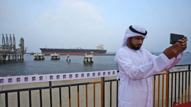 An Emirati official takes a selfie as an oil tanker approaches the new Jetty during the launch of the new $650 million