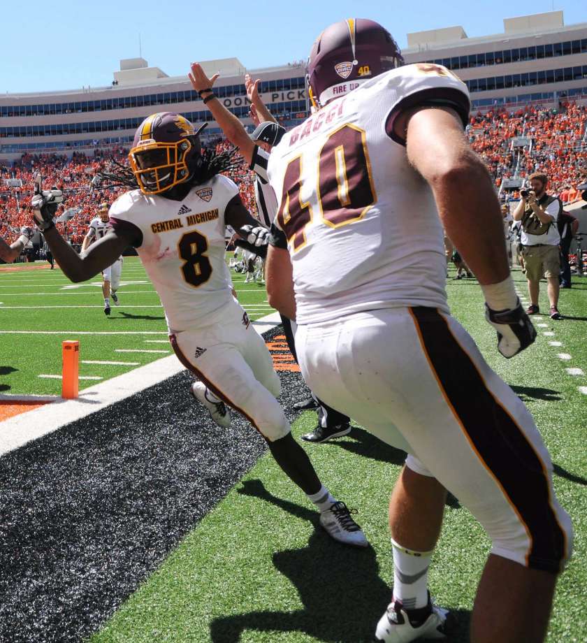 A referee signals a touchdown as Central Michigan wide receiver Corey Willis celebrates with his teammate running back Joe Bacci after scoring the winning touchdown in the final seconds of an NCAA college football game between against Oklahoma St