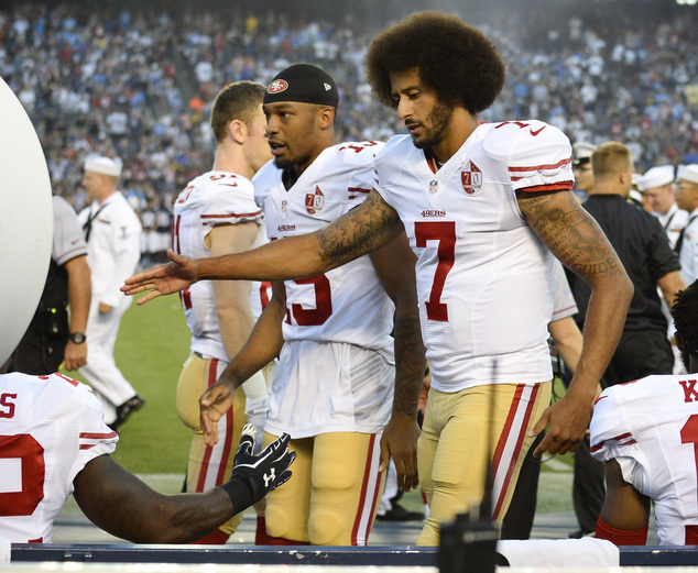 San Francisco 49ers quarterback Colin Kaepernick greets teammates after kneeling during the national anthem before the team's NFL preseason football game aga