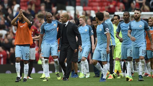 Manchester City's Spanish manager Pep Guardiola and his players celebrate on the pitch after the English Premier League football match between Manchester United and Manchester City at Old Trafford in Manchester north west England