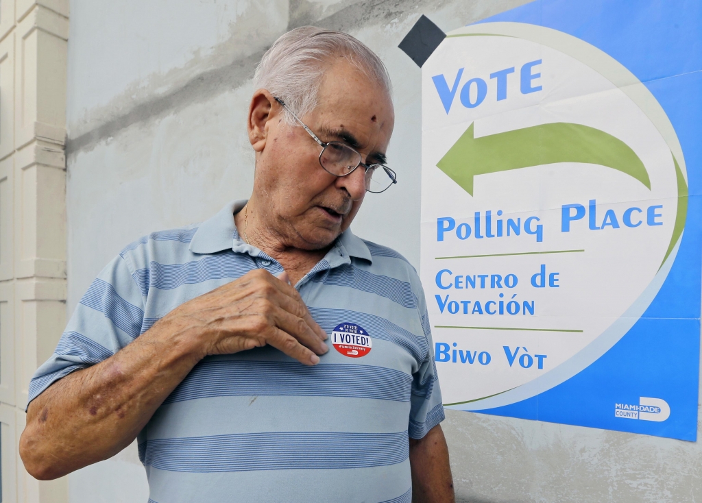 Orlando Fernandez places a sticker on his shirt after casting his primary vote Tuesday Aug. 30 2016 in Hialeah Fla