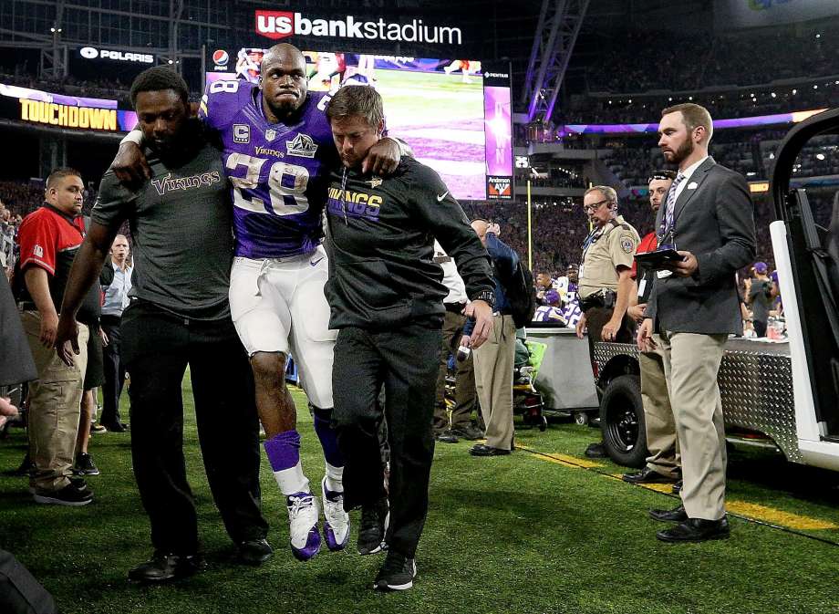 Minnesota Vikings running back Adrian Peterson is helped to the locker room in the third quarter of Sunday night’s game after suffering a knee injury against the Green Bay Packers