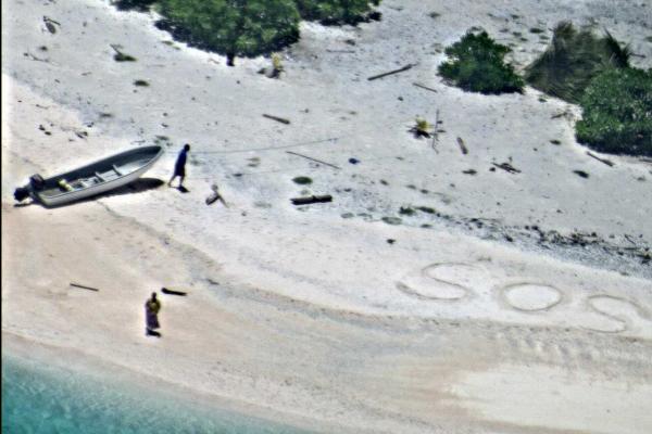 U.S. Navy stranded mariners signal for help as a Navy P-8A Poseidon aircraft crew flies in support of a Coast Guard search and rescue mission on an uninhabited island in Micronesia Hawaii