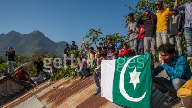 Kashmiri Muslims hold a flag on a roof top as they attend the funeral of Nasir Shafi an 11-year-old who was killed