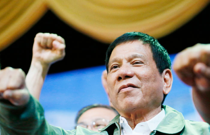 Philippine President Rodrigo Duterte poses with a fist bump during his “Talk with the Airmen” on the anniversary of the 205th Presidential Airlift Wing at the Philippine Air Force headquarters in suburban Pasay city southeast of Manila on Tuesday