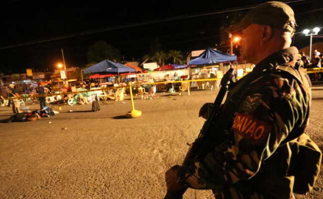 STAY STRONG DAVAO. A soldier keeps watch at a night market in Davao City where a blast killed at least 14 people and hurt more than 60 others late Friday night. The explosion took place amid a security alert due to an ongoing major offensive against