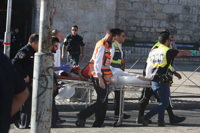 Israeli medics carry an injured man following a Palestinian stabbing attack near the Herod's Gate entrance to the Old City of Jerusalem