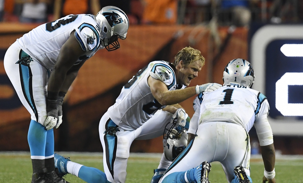 Panthers offensive lineman Donald Hawkins and tight end Greg Olsen check the health of quarterback Cam Newton