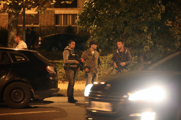 Police officers stand guard as they take part in a raid in Boussy-Saint-Antoine east of Paris Thursday Sept. 8 2016. French police detained three women