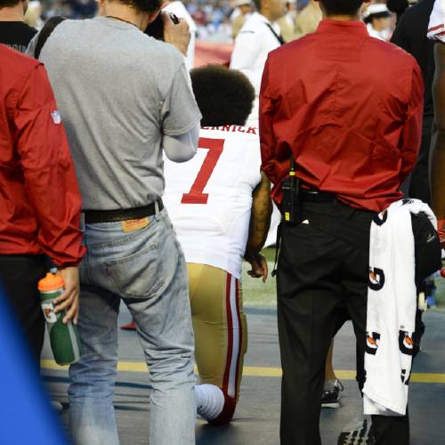 49ers quarterback Colin Kaepernick middle kneels during the national anthem before the team's NFL preseason football game against the San Diego Chargers Thursday Sept. 1 2016 in San Diego