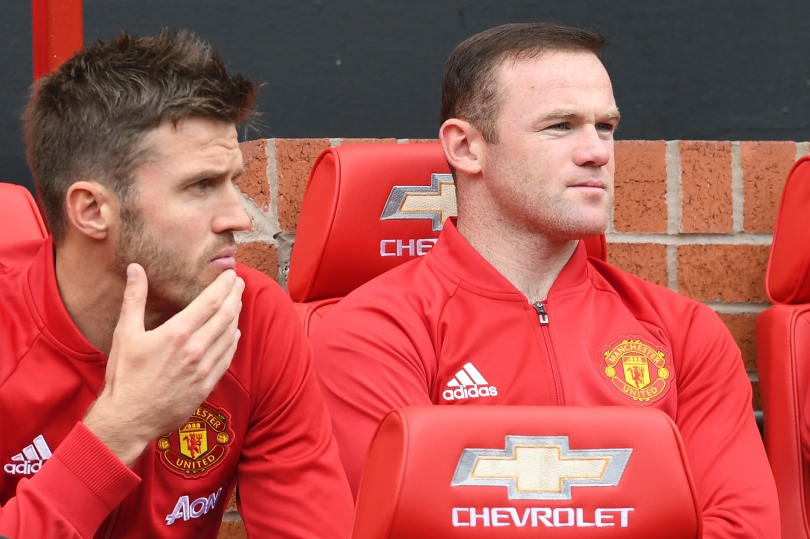 Manchester United's English striker Wayne Rooney sits on the substitutes bench with Manchester United's English midfielder Michael Carrick during the English Premier League football match between Manchester United and Leicester City. AFP