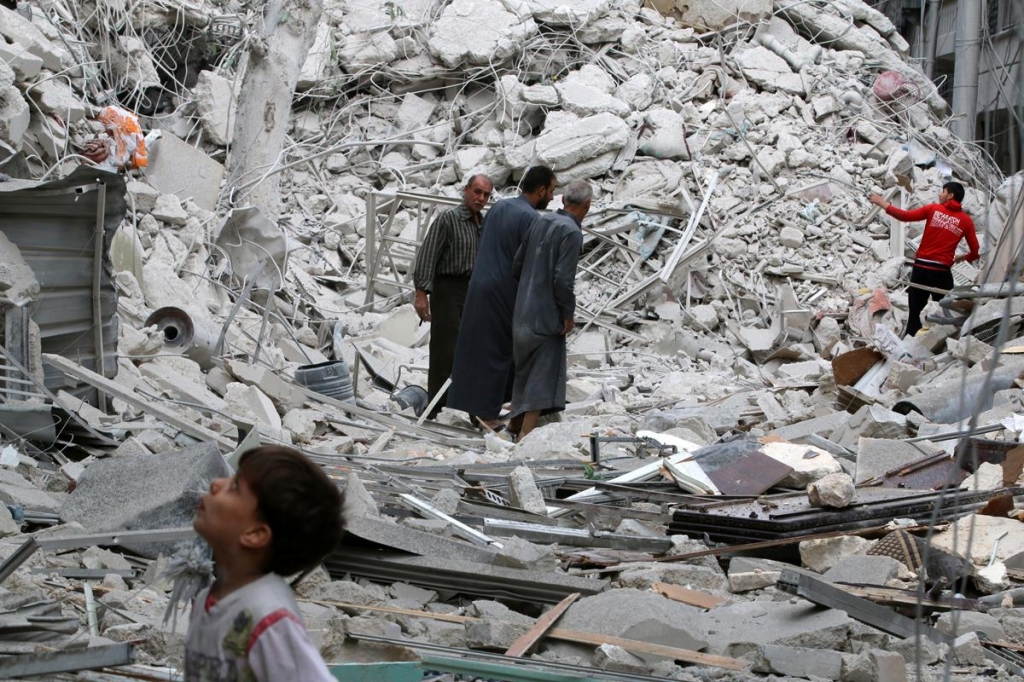 People inspect a damaged site after airstrikes on the rebel held al Qaterji neighbourhood of Aleppo Syria