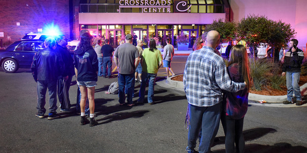 People stand near the entrance of Crossroads Center shopping mall in St. Cloud Minnesota