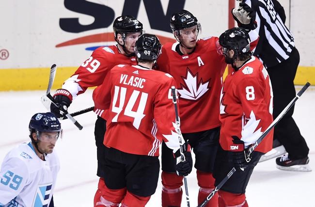 Team Canada centre Jonathan Toews celebrates with teammates as Team Europe defenceman Roman Josi skates by during third period World Cup of Hockey action in Toronto on Wednesday