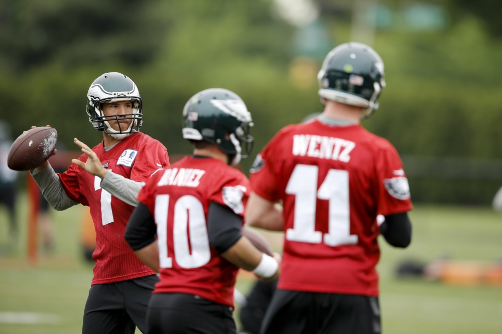 Philadelphia Eagles quarterback Sam Bradford throws a pass as Chase Daniel and Carson Wentz look on at the team's NFL football training facility Tuesday