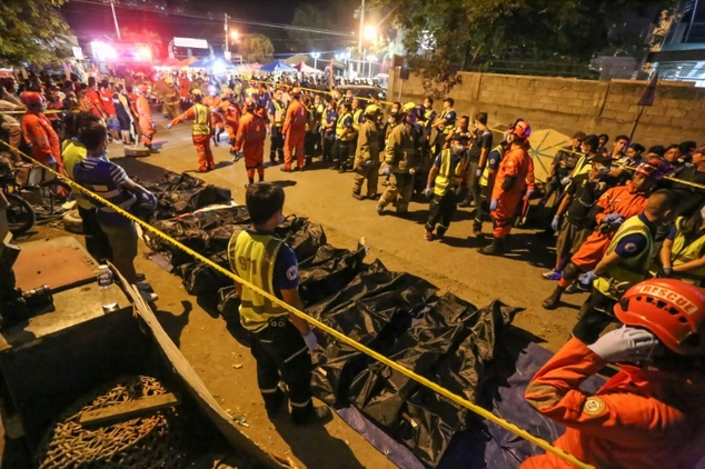 Rescue workers line up bags with dead bodies of victims of an explosion at a night market in Davao City on the southern Philippine island of Mindanao early