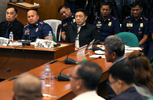 Philippine Police Chief Ronald Dela Rosa second from left looks at former Filipino militiaman Edgar Matobato during his testimony at the Philippine Senate in Pasay south of Manila Philippines on Thursday Sept. 15 2016. Matobato said that Philippine