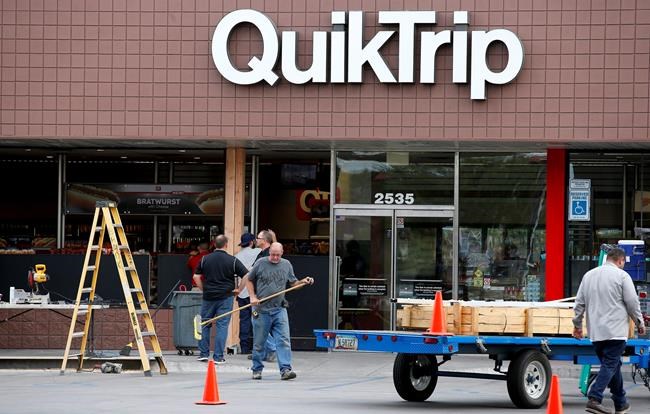 Construction workers continue cleaning up in front of a Quick Trip store hours after a driver plowed into two police officers Tuesday Sept. 13 2016 in Phoenix. Police said Marc La Quon Payne 44 apparently drove his vehicle at the officers before hittin