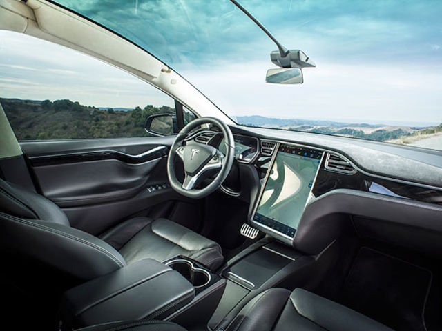 The interior of a Tesla car with a large display screen on the dashboard